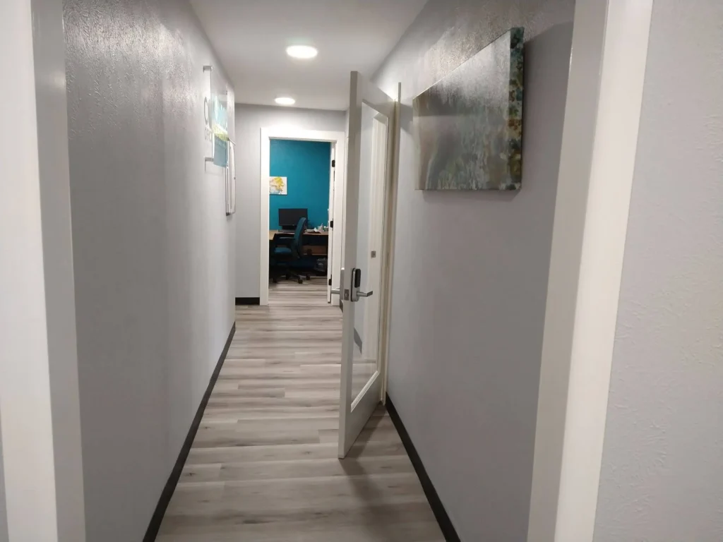 Front hallway from restrooms, leading to Suite A1, with open door from lobby